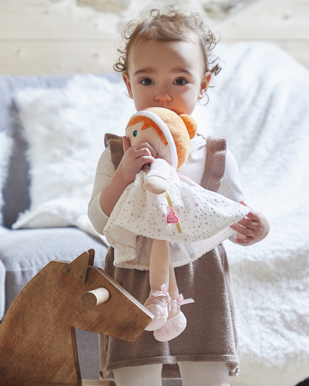 Toddler cuddling a Kaloo Valentine soft doll